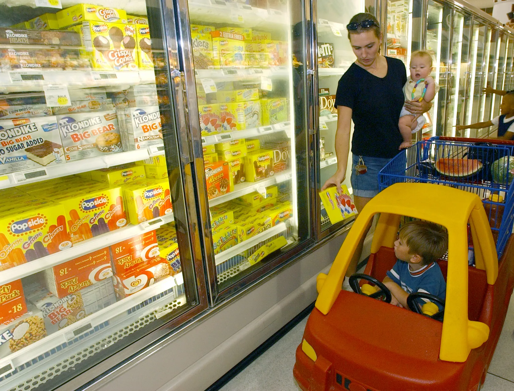shopping cart with groceries in supermarket aisle