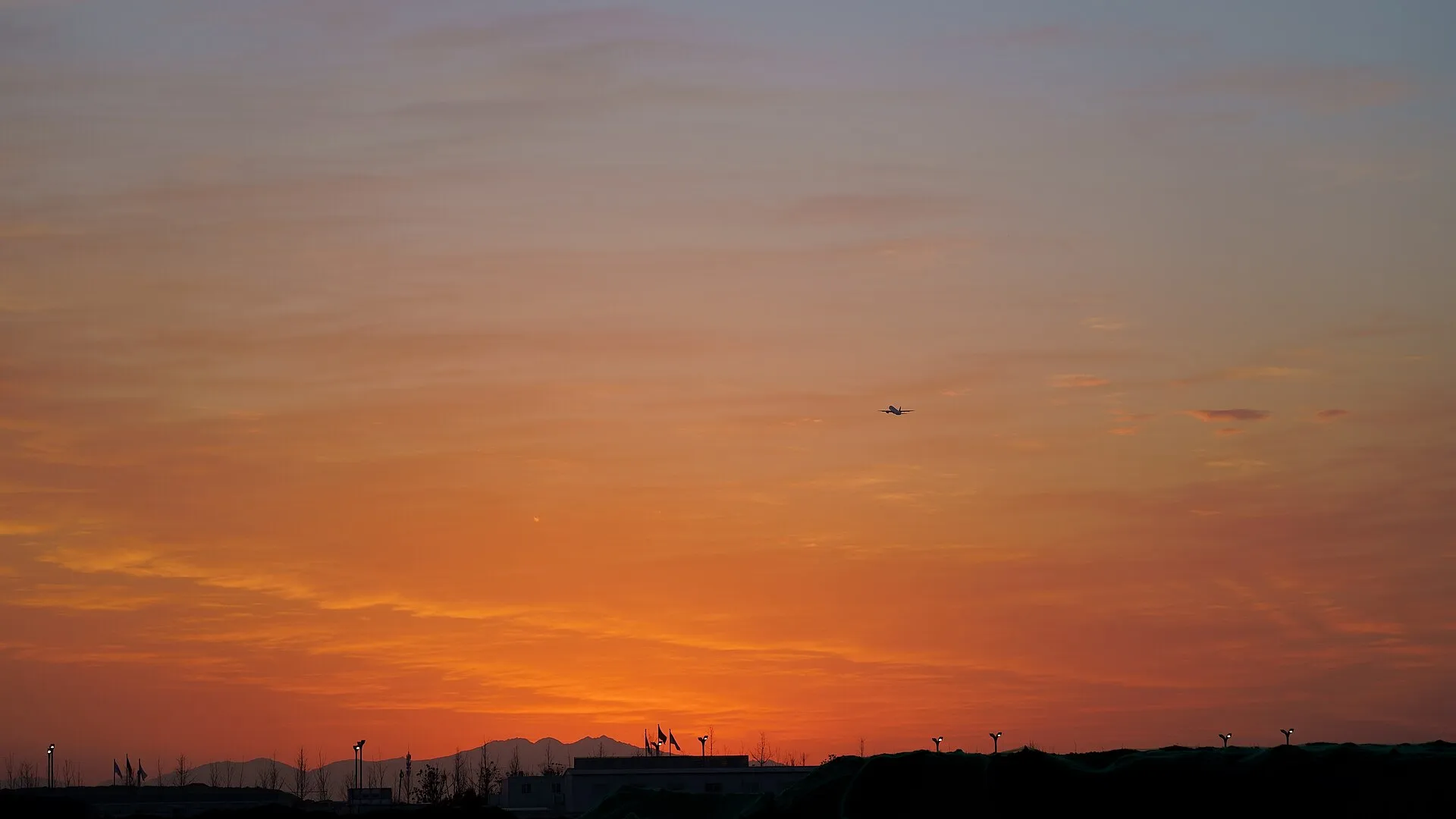 airplane taking off at sunset